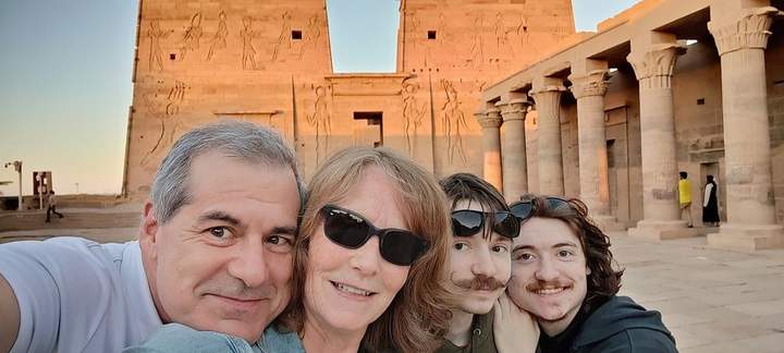 Família tirando uma selfie diante do pilone iluminado pelo sol do Templo de File, Assuã