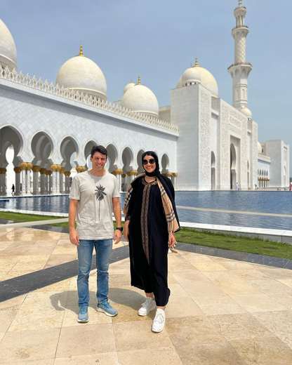 Casal junto ao espelho d'água da Grande Mesquita Sheikh Zayed, em Abu Dhabi