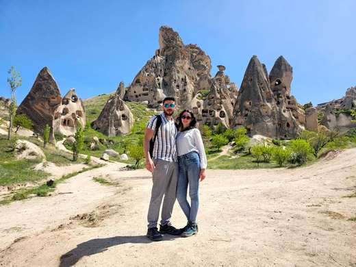 Casal entre as moradias rupestres do vale de Uchisar, na Capadócia, Turquia